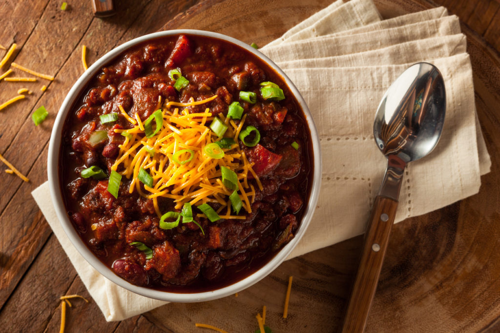 Comforting bowl of vegie chilli with cheese and chives